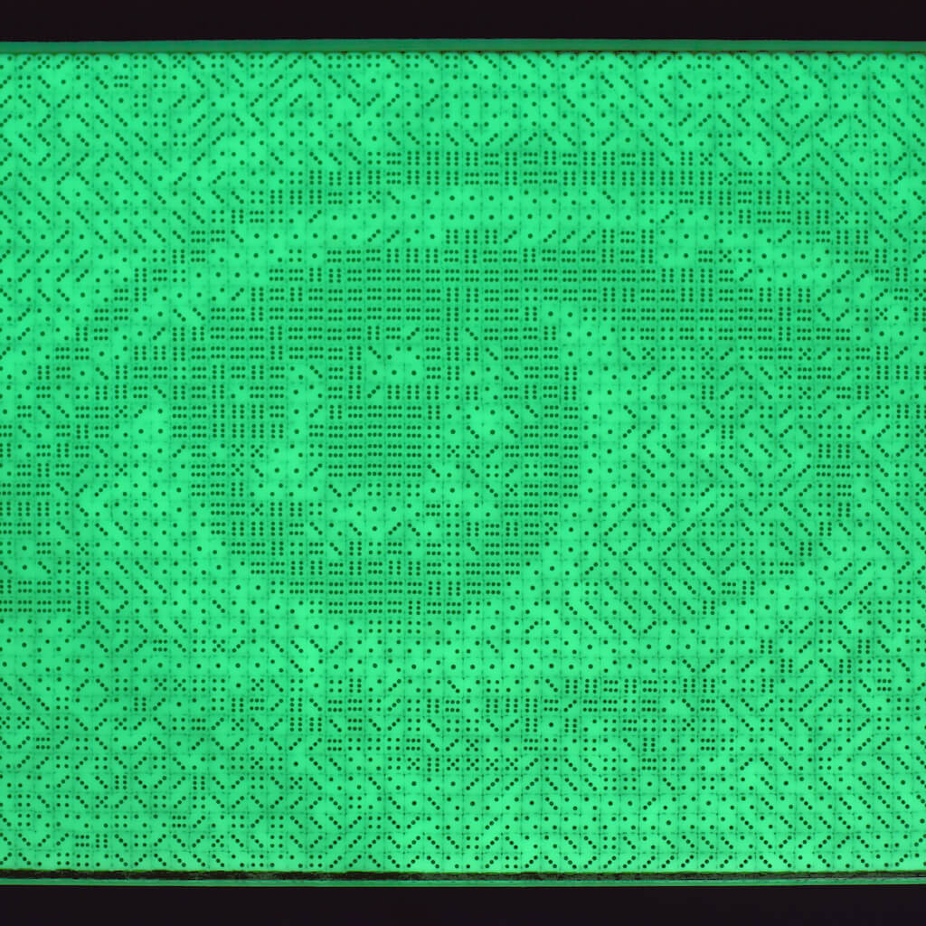 thumbnail - Dobbelstenenmozaïek van een vrouwenoog. De fosforescerende dobbelstenen geven in de schemering een lichtgroene gloed.